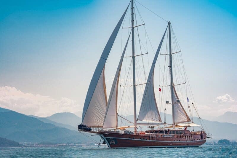 Traditional wooden charter yacht deck with seating and sea view in the Mediterranean
